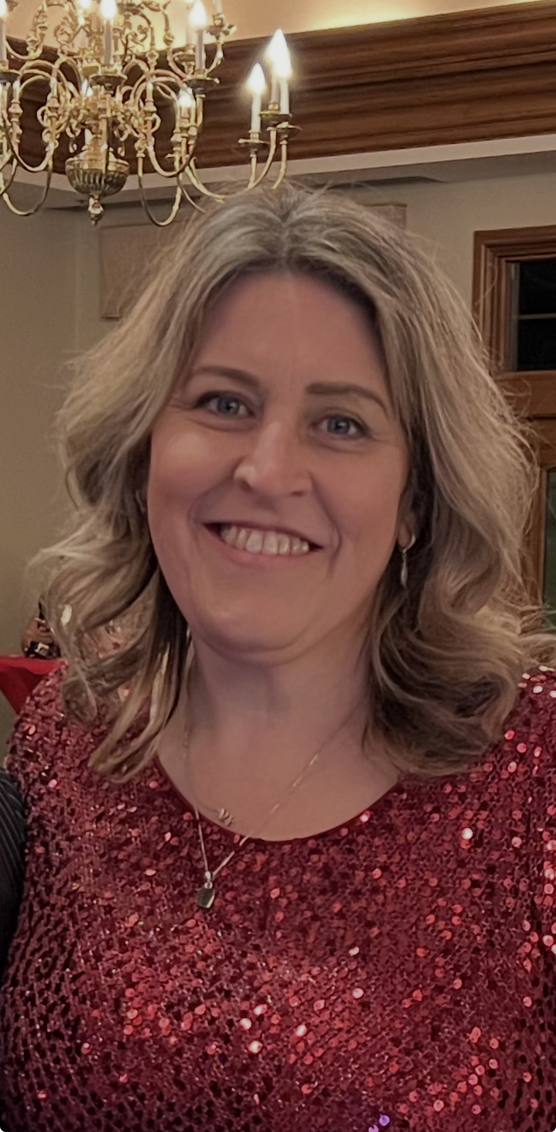 Cathie smiling in a burgundy sequined top